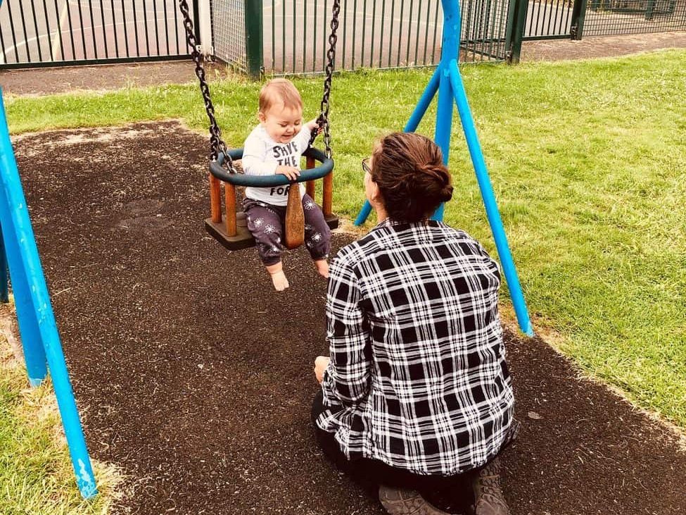 Home-Start Cambridgeshire volunteer with baby on swing